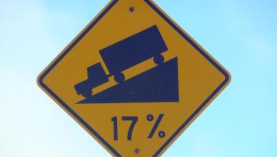 A sign showing a truck on a street grading