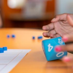 A student rolls a fist-sized 10 sided die