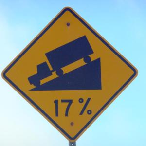 A sign showing a truck on a street grading