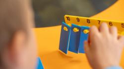 Over the shoulder of a student adjusting a number balance. 