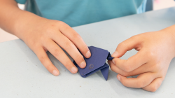 Student folding a frog