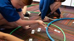 Students sort number cards into hoops symbolising Venn diagrams