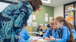 Teacher looking at students' work